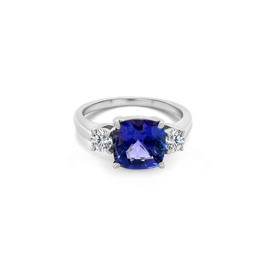 A, cushion-cut, tanzanite, gemstone, sits, center, flanked, by, two, sparkling, round, diamonds, in, a, stunning, trilogy, design.