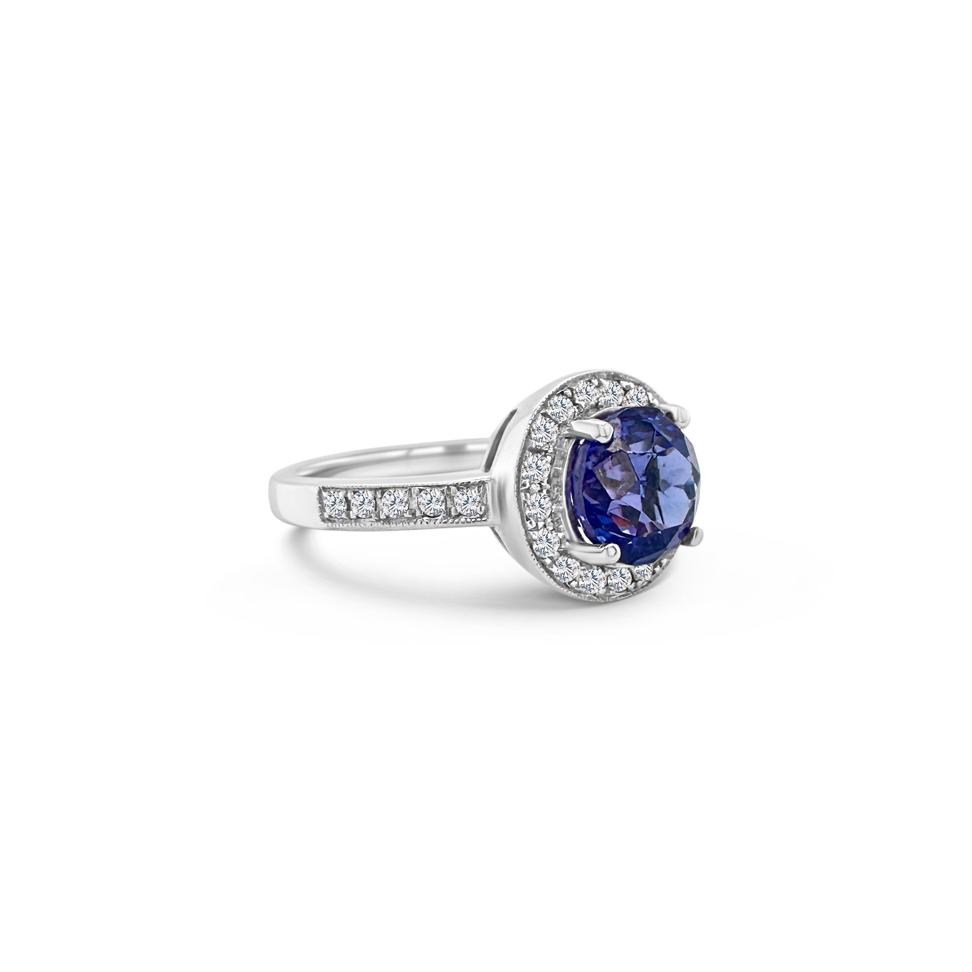 Round Tanzanite & Diamond Halo Ring: tanzanite ring, diamond halo, round cut gemstone, jewelry, gemstone ring, halo ring, blue gemstone, diamond accents, precious stone, fine jewelry.