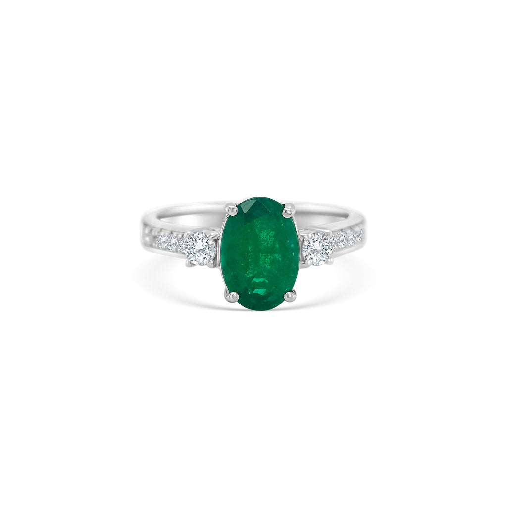 Oval emerald ring, emerald trilogy ring, emerald and diamond ring, diamond trilogy ring, diamond and emerald jewelry, fine jewelry, elegant ring, gemstone ring, luxury jewelry, three-stone ring, green gemstone ring."