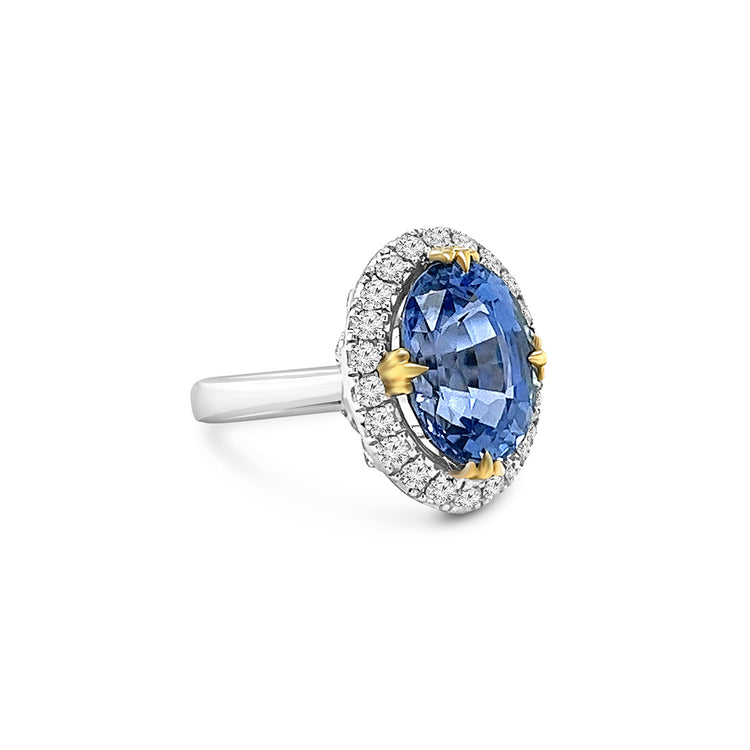 A, captivating, oval, sapphire, center, stone, surrounded, by, sparkling, diamonds, set, in, a, halo, design, atop, a, polished, band.