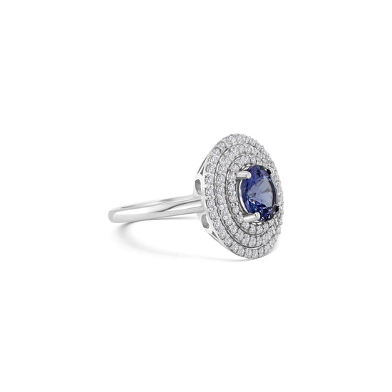 Round tanzanite ring," "Diamond triple halo ring," "Tanzanite and diamond ring," "Halo engagement ring," "Gemstone halo ring," "Luxury jewelry," "Fine jewelry," "Statement ring," "Fashion ring," "Precious gemstone ring."