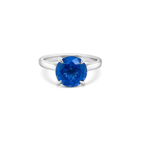 Round solitaire tanzanite ring, sparkling blue gemstone, elegant jewelry piece, minimalist design, timeless beauty.