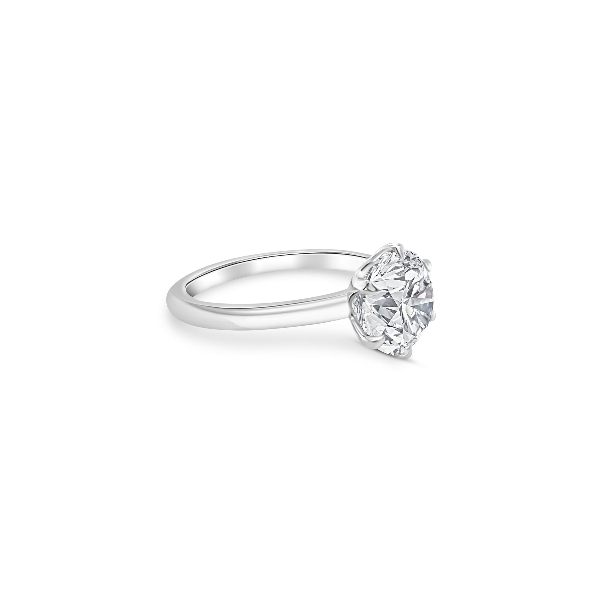 A, round, brilliant, solitaire, diamond, ring, with, a, sparkling, center, stone, set, in, a, prong, setting, on, a, polished, metal, band.