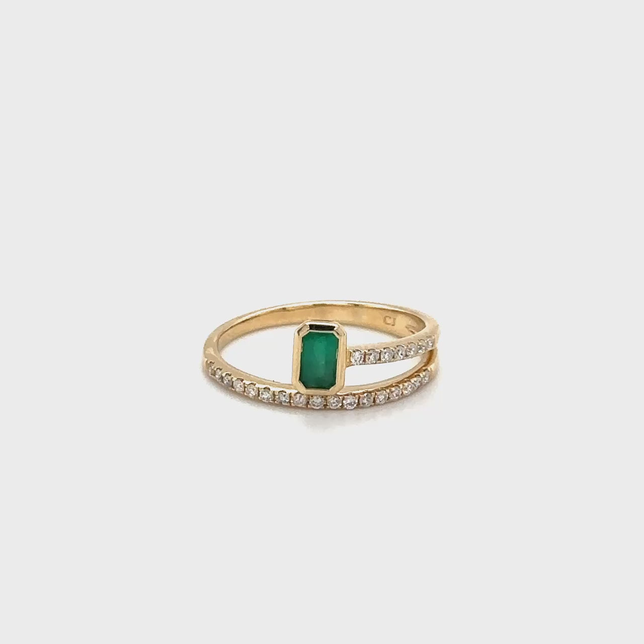 A luxurious emerald and diamond ring, featuring a vivid green emerald stone, surrounded by sparkling diamonds, set in lustrous white gold.