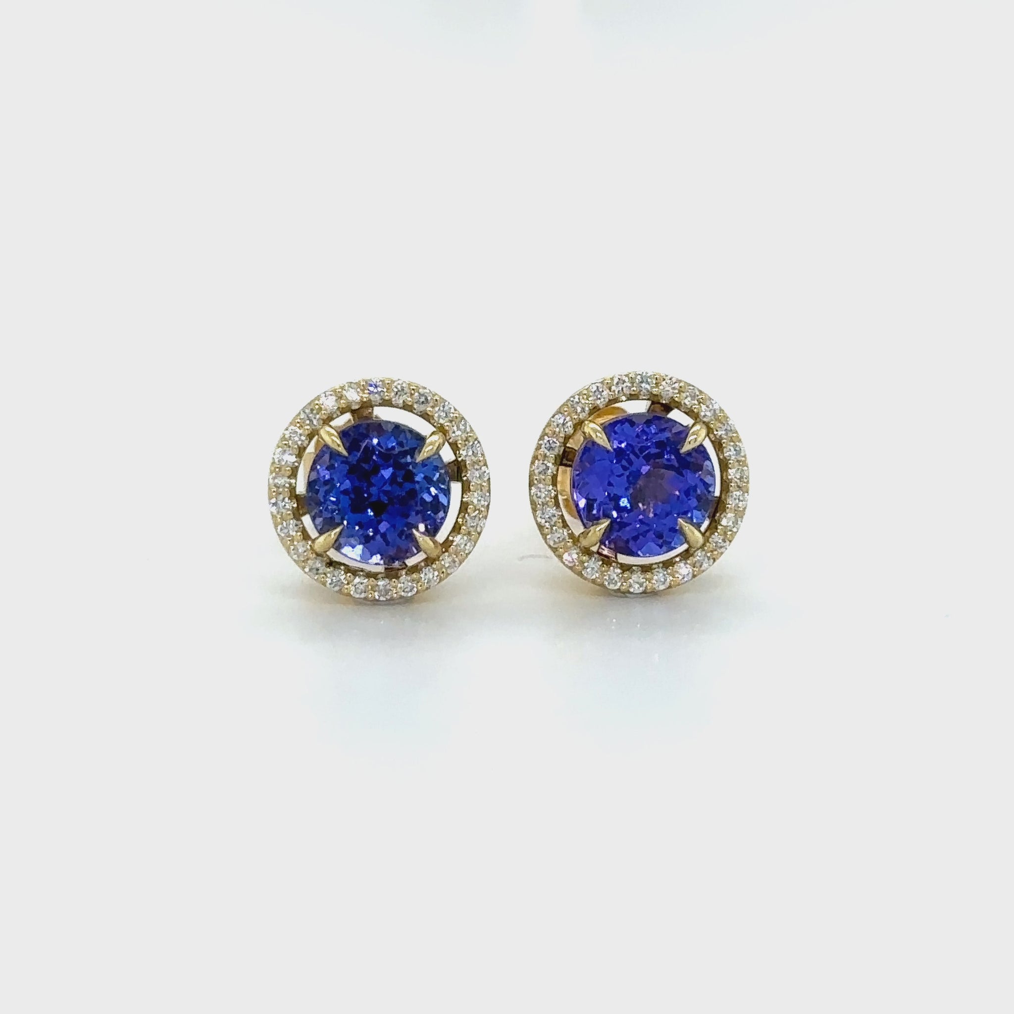 Exquisite round Tanzanite stud earrings, surrounded by a dazzling halo of brilliant diamonds. Elegant jewelry for special occasions, featuring vibrant Tanzanite gems and sparkling diamond accents. Stunning halo design, showcasing the beauty of round Tanzanite stones, complemented by the brilliance of diamonds. Perfect accessories to add a touch of glamour and sophistication to any ensemble