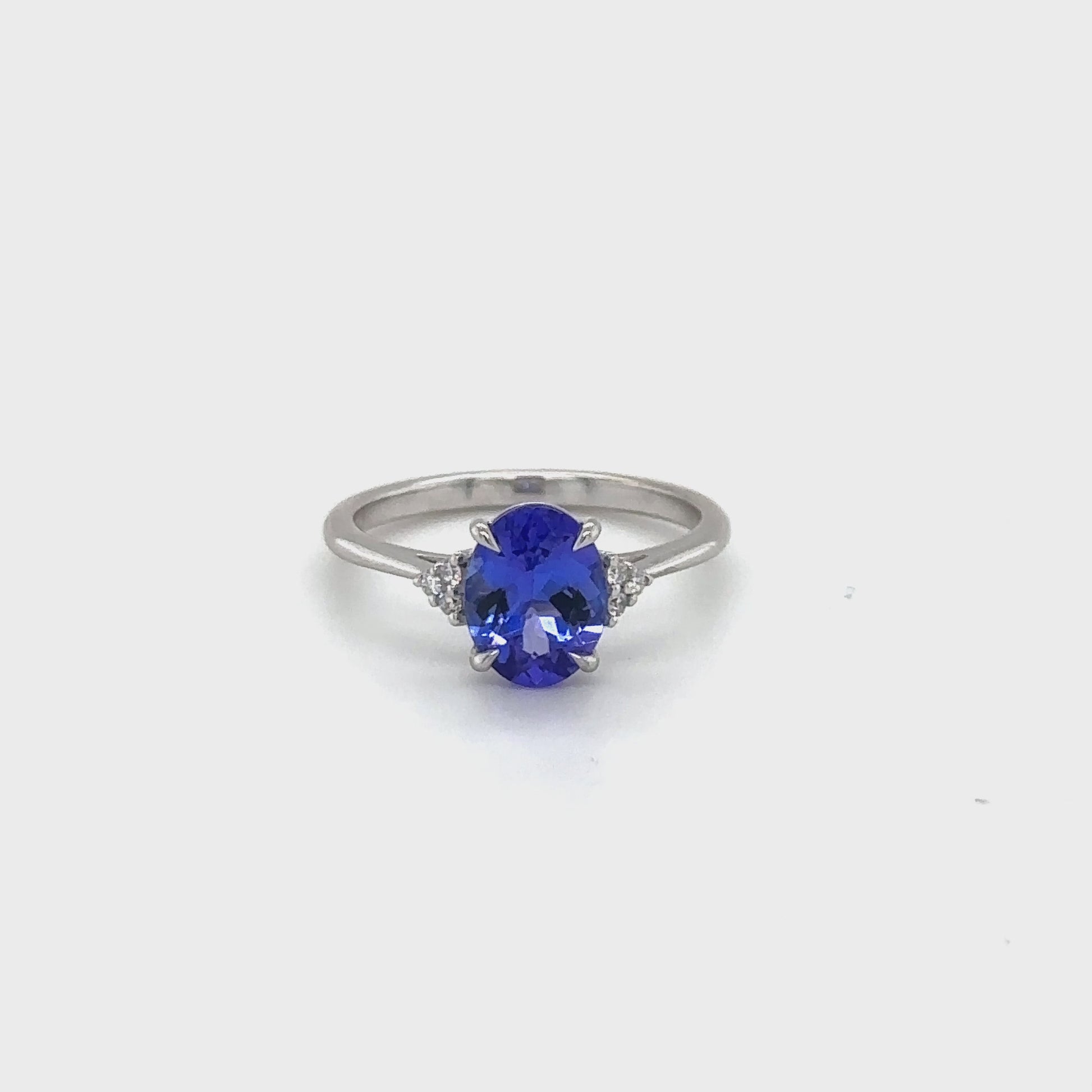 Oval Tanzanite Diamond Ring, Elegant Tanzanite Jewelry, Sparkling Diamond Accents, Luxury Gemstone Ring, Statement Tanzanite Ring, Sophisticated Oval Cut Design, Exquisite Diamond and Tanzanite Combination, Glamorous Fine Jewelry Piece, Brilliant Gemstone Ring, Dazzling Tanzanite and Diamond Setting