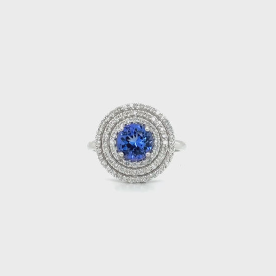 Round tanzanite ring," "Diamond triple halo ring," "Tanzanite and diamond ring," "Halo engagement ring," "Gemstone halo ring," "Luxury jewelry," "Fine jewelry," "Statement ring," "Fashion ring," "Precious gemstone ring."