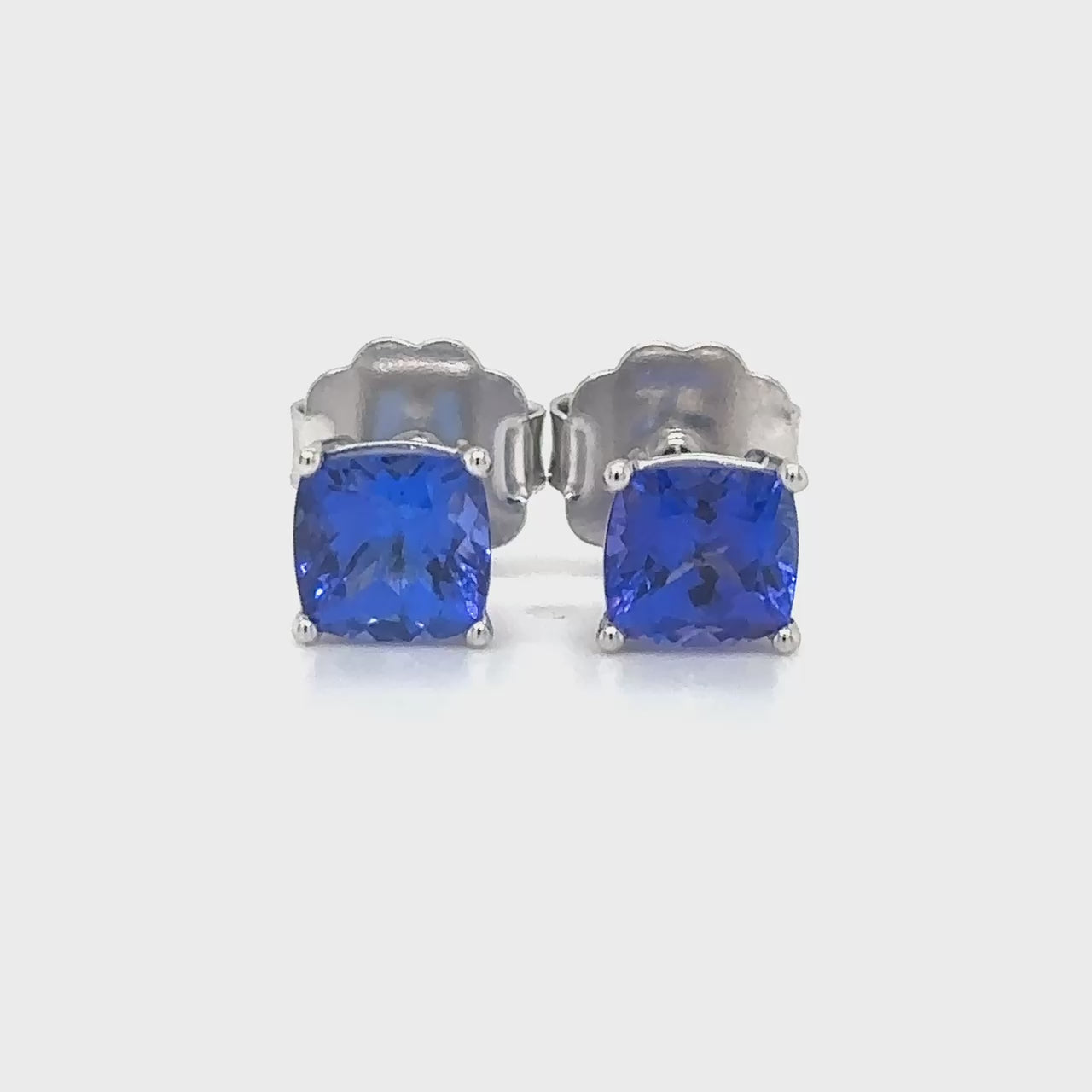 "Cushion Cut Tanzanite Stud Earrings," "Tanzanite Stud Earrings," "Fine Jewelry," "Luxury Earrings," "Fashion Earrings," "Gemstone Jewelry," "Sparkling Tanzanite Earrings," "Statement Earrings," "Elegant Jewelry," "Special Occasion Earrings," "Cushion Cut Earrings," "Tanzanite Jewelry," "Timeless Jewelry," "Handcrafted Earrings," "Unique Gemstone Studs."