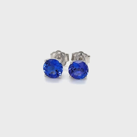 Round Tanzanite stud earrings, sparkling Tanzanite studs, elegant Tanzanite ear studs, precious Tanzanite gems, classic round Tanzanite earrings, beautiful blue Tanzanite studs, stunning Tanzanite jewelry, dainty Tanzanite studs, exquisite round Tanzanite earrings, vibrant Tanzanite studs.