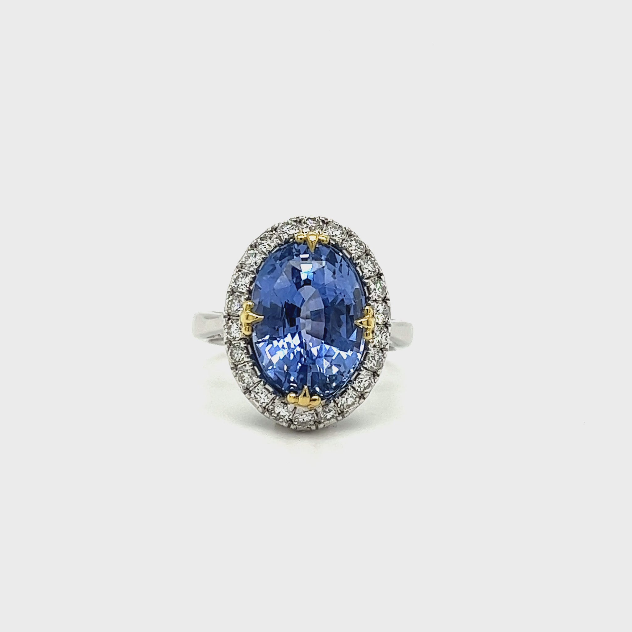 A, captivating, oval, sapphire, center, stone, surrounded, by, sparkling, diamonds, set, in, a, halo, design, atop, a, polished, band.
