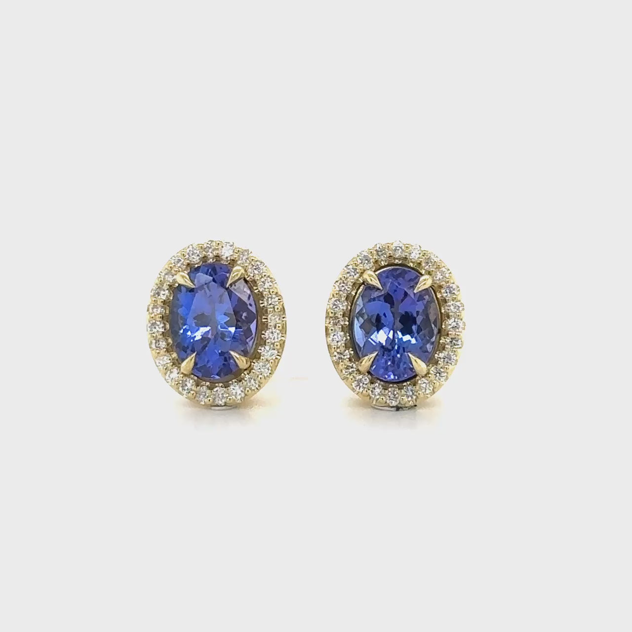 Oval Tanzanite & Diamond Halo Stud Earrings, Tanzanite stud earrings, Diamond halo earrings, Oval gemstone earrings, Halo stud earrings, Tanzanite and diamond jewelry, Gemstone stud earrings, Oval cut earrings, Diamond accent earrings, Elegant stud earrings.