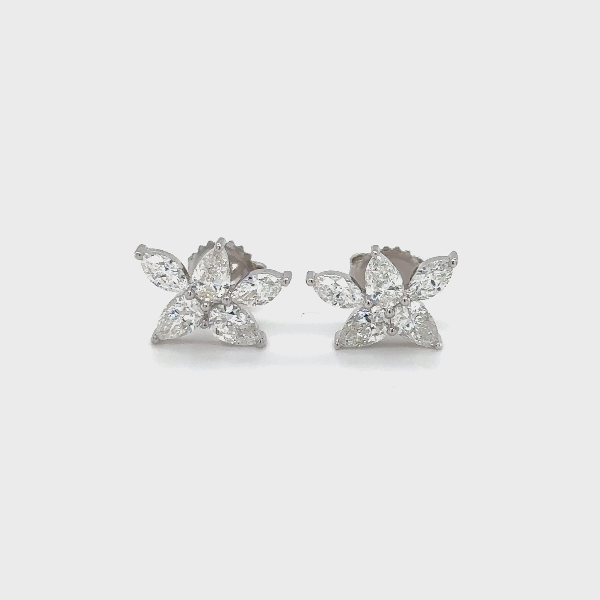 Floral stud earrings featuring pear and marquise-shaped gems, delicate botanical design, nature-inspired jewelry, elegant flower studs, pear-cut and marquise-cut stones, sophisticated floral accessories, sparkling gemstone studs, nature-themed earrings, exquisite botanical craftsmanship, stylish pear and marquise studs.