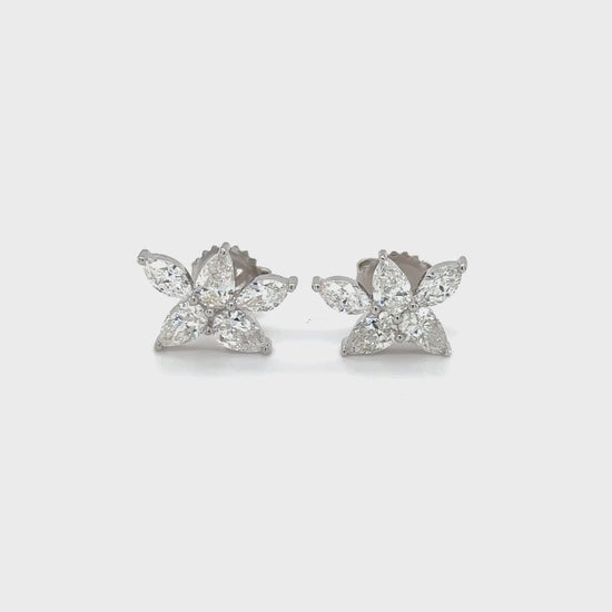 Floral stud earrings featuring pear and marquise-shaped gems, delicate botanical design, nature-inspired jewelry, elegant flower studs, pear-cut and marquise-cut stones, sophisticated floral accessories, sparkling gemstone studs, nature-themed earrings, exquisite botanical craftsmanship, stylish pear and marquise studs.