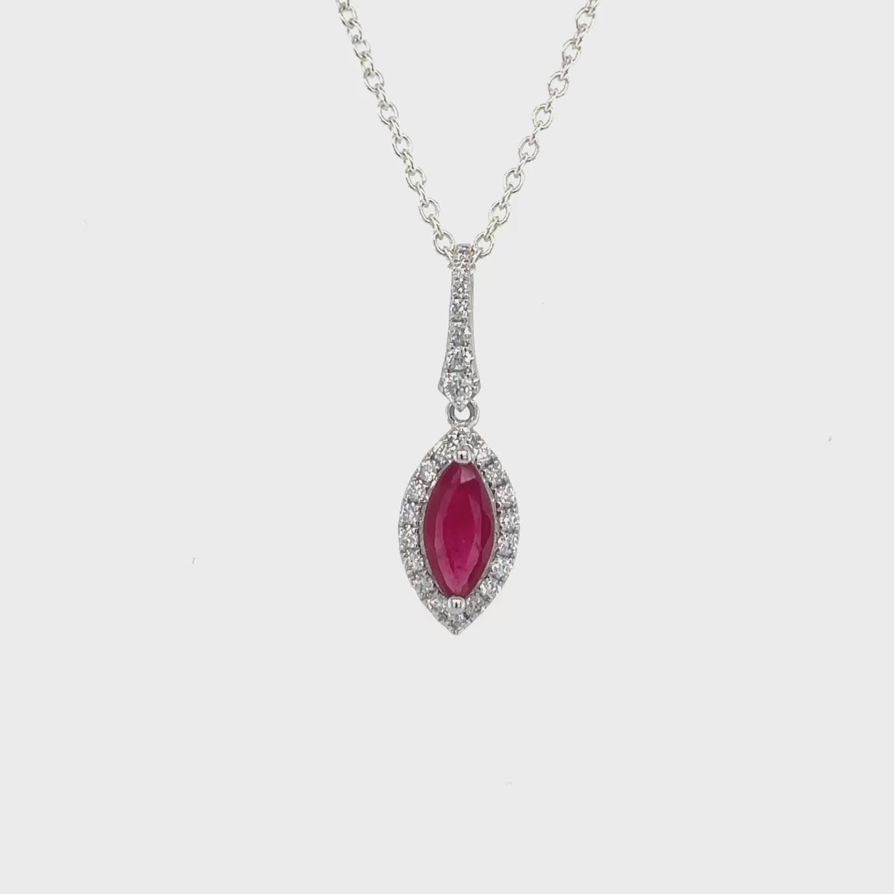  a stunning marquise-cut ruby surrounded by a sparkling halo of diamonds. This exquisite piece exudes elegance and sophistication, perfect for adding a touch of glamour to any ensemble.