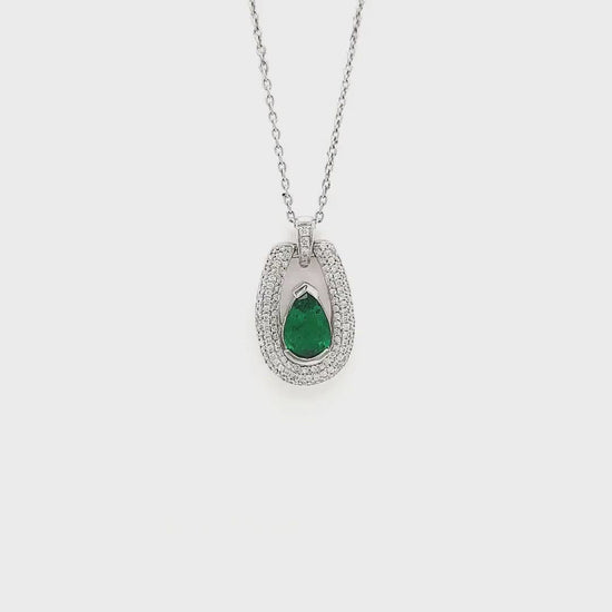 A stunning, pear-shaped emerald pendant, exquisite diamond detailing, elegant jewelry piece, floating design, luxurious emerald and diamond combination, eye-catching gemstone pendant, sophisticated jewelry accessory, radiant pear-cut emerald, sparkling diamond accents, timeless and chic pendant.