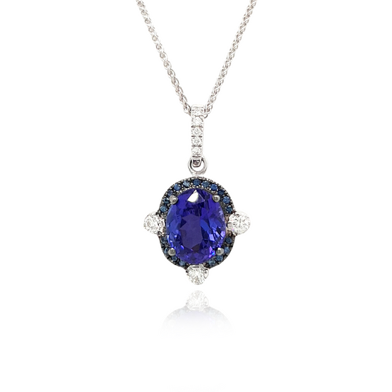 A stunning Oval Tanzanite pendant surrounded by a dazzling halo of diamonds. The rich, violet hues of the Tanzanite gemstone are accentuated by the sparkling brilliance of the surrounding diamonds. This elegant pendant is a timeless piece that effortlessly combines the allure of the oval-shaped Tanzanite with the glamour of a diamond halo. Perfect for adding a touch of sophistication to any ensemble.